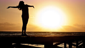 Image of woman on a boardwalk at sunset